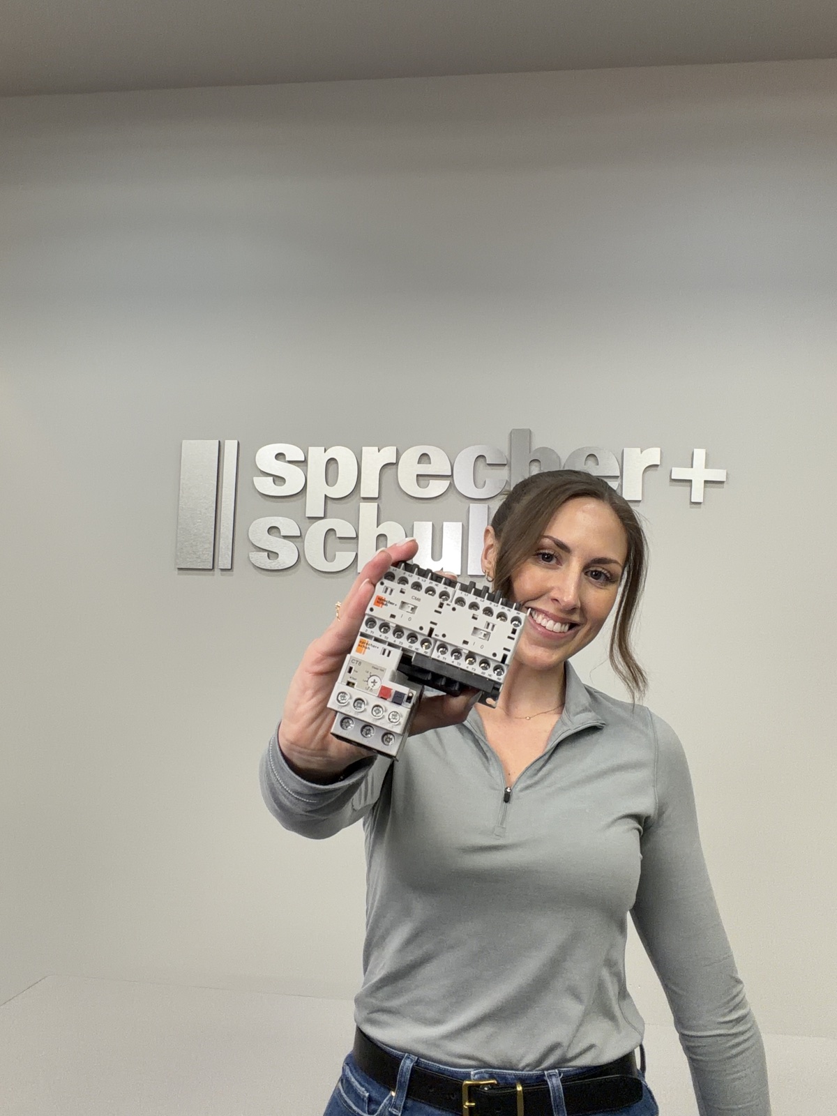 Jordan Yates holding an industrial motor control component during a product demonstration